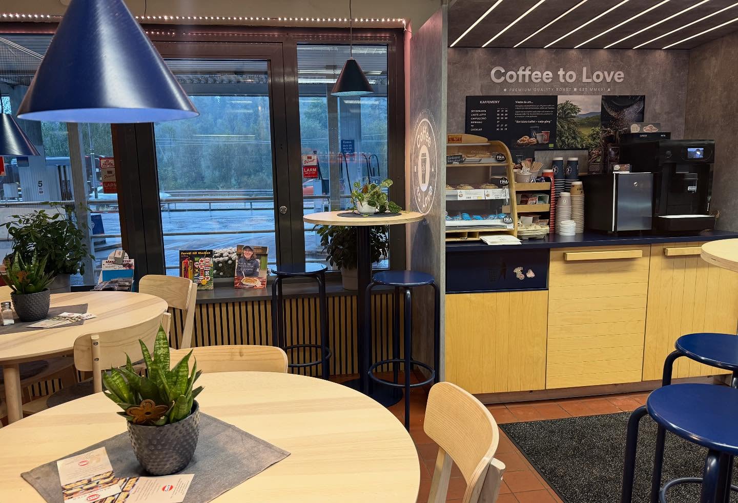 Fikahörna hos Gånghester Bilservice med kaffemaskin och ljusa träbord